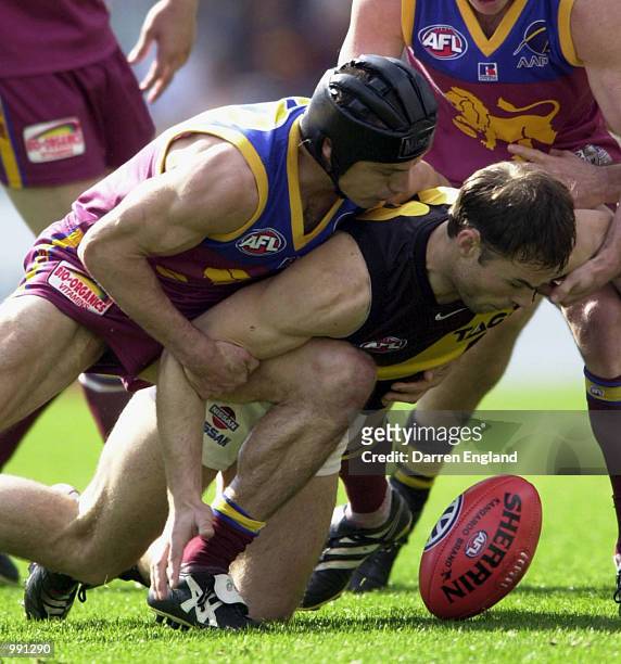Jason Torney of Richmond is tackled by Shaun Hart of Brisbane during the round 19 AFL match between the Brisbane Lions and the Richmond Tigers played...