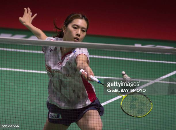 Aya Ohori of Japan hits a return against Zhang Beiwen of China during their women's singles badminton match at the Indonesia Open in Jakarta on July...
