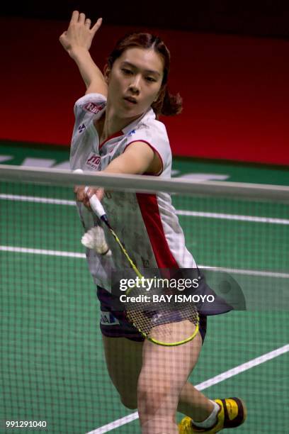 Aya Ohori of Japan hits a return against Zhang Beiwen of China during their women's singles badminton match at the Indonesia Open in Jakarta on July...