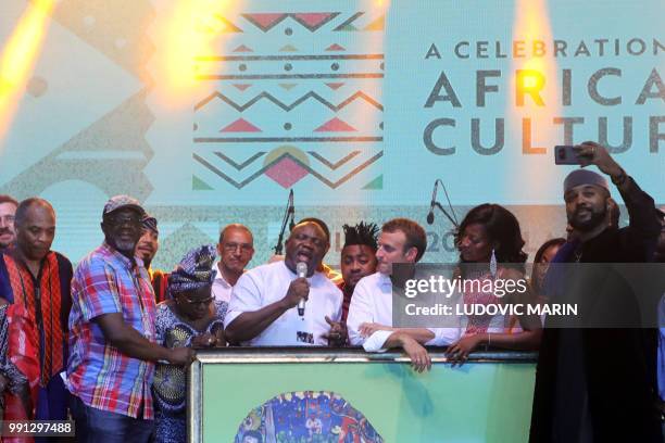 French President Emmanuel Macron looks on Nigerian artists Femi Kuti, Youssou N'Dour and Angelique Kidjo perform at the Shrine Afrika in Lagos on...