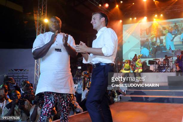 French President Emmanuel Macron dances next to Lagos Governor Akinwunmi Ambode at the Shrine Afrika in Lagos on July 3, 2018. - French President...