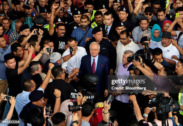 Najib Razak, Malaysia's former prime minister, center, shakes hands with a supporter as he leaves the Kuala Lumpur Courts Complex in Kuala Lumpur,...