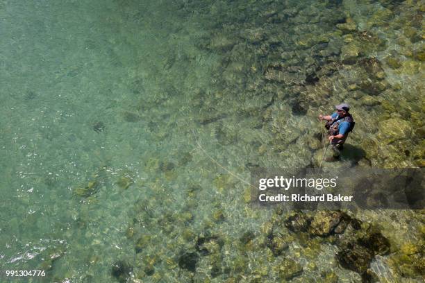 Fly-fisherman casts off in clear waters of the Sava Bohinjnka river, on 18th June 2018, in Bohinjska Bela, Bled, Slovenia.