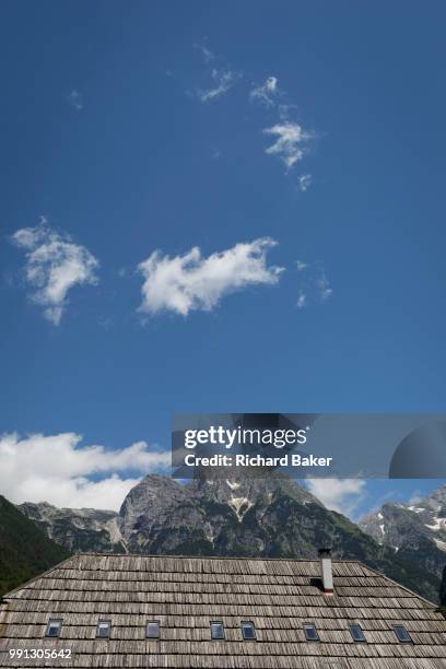 The wooden roof of a municipal building beneath the highest peaks in the Slovenian Julian Alps, on 22nd June 2018, in Trenta, Triglav National Park,...