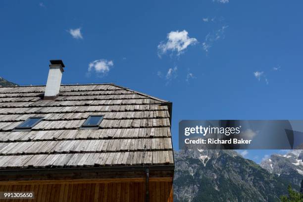 The wooden roof of a municipal building beneath the highest peaks in the Slovenian Julian Alps, on 22nd June 2018, in Trenta, Triglav National Park,...