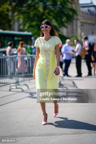 Giovanna Battaglia wears a yellow dress with lace, outside Chanel, during Paris Fashion Week Haute Couture Fall Winter 2018/2019, on July 3, 2018 in...