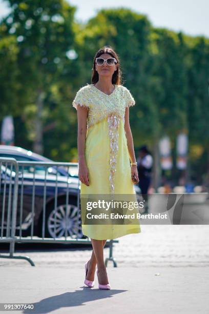 Giovanna Battaglia wears a yellow dress with lace, outside Chanel, during Paris Fashion Week Haute Couture Fall Winter 2018/2019, on July 3, 2018 in...