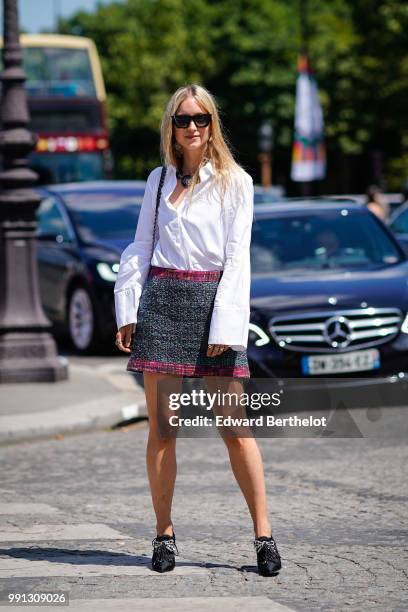 Charlotte Greoneveld wears a white shirt, a Chanel bag, a blue and purple tweed skirt , outside Chanel, during Paris Fashion Week Haute Couture Fall...
