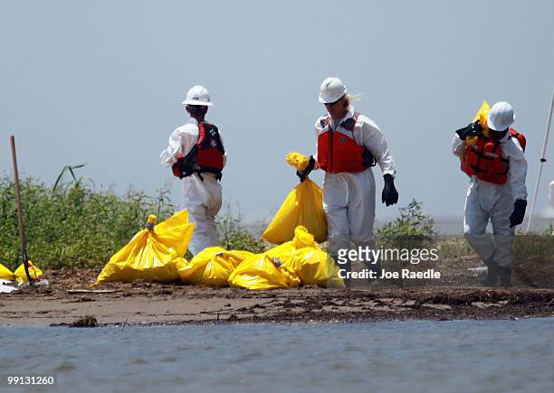 Workers clean a beach after tar balls washed up as efforts continue to contain BP's massive oil spill on May 12, 2010 in South Pass, Louisiana. The...