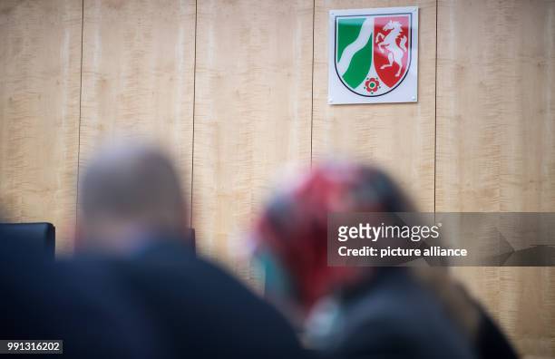 The central council of Muslims and Islam's representatives sit in front of the federal coat of arms in the higher administrative court in Muenster,...