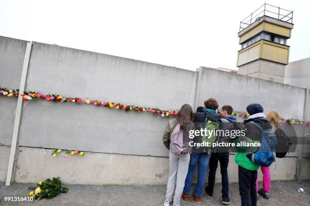 Teenagers put roses into the wall segments at the Berlin Wall Commemoration Site at Bernauer Strasse in Berlin, Germany, 9 November 2017. Teenagers...