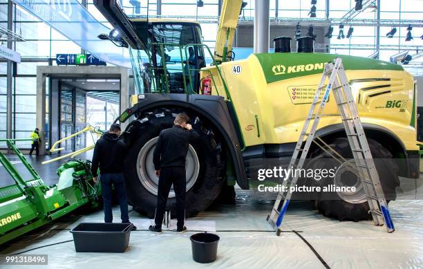 An assistant cleans a vehicle at the stand of the company Krone at the agricultural fair Agritechnica in Hanover, Germany, 9 November 2017. Around...