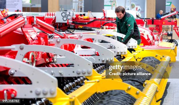 An assistant cleans a vehicle at the stand of the company Poettinger at the agricultural fair Agritechnica in Hanover, Germany, 9 November 2017....