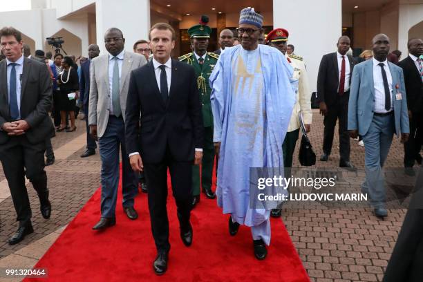 French President Emmanuel Macron and Nigerian President Muhammadu Buhari speak in Abuja on July 3, 2018. - French President Emmanuel Macron has...