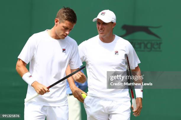 Ken Skupski of Great Britain and Neal Skupski of Great Britain discuss tactics during their Men's Doubles first round match against Ilija Bozoljac of...