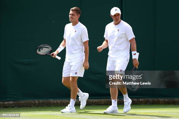 Ken Skupski of Great Britain and Neal Skupski of Great Britain walk across the court during their Men's Doubles first round match against Ilija...