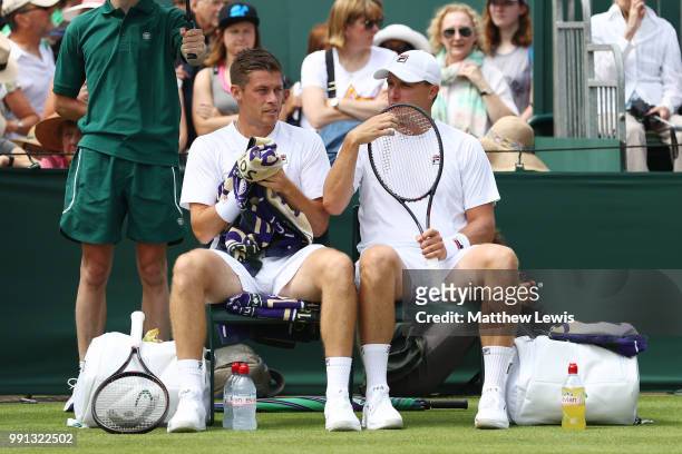 Ken Skupski of Great Britain and Neal Skupski of Great Britain during a break in their Men's Doubles first round match against Ilija Bozoljac of...