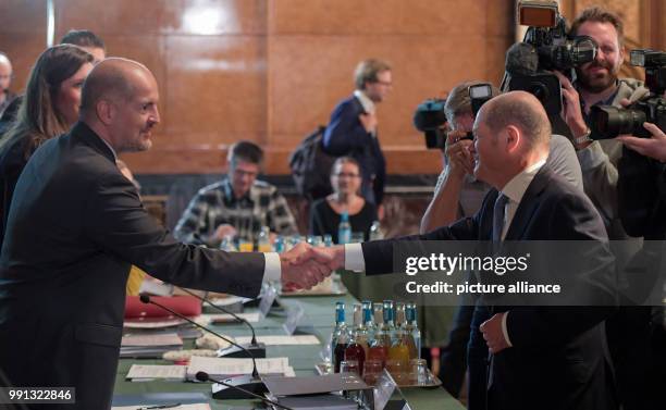 Hamburg's Mayor Olaf Scholz greets the chairman Milan Pein at a meeting of the G20 special committee at the city hall in Hamburg, Germany, 9 November...