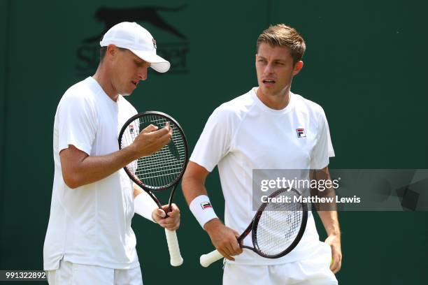 Ken Skupski of Great Britain and Neal Skupski of Great Britain discuss tactics during their Men's Doubles first round match against Ilija Bozoljac of...