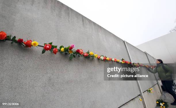 Teenagers put roses into the wall segments at the Berlin Wall Commemoration Site at Bernauer Strasse in Berlin, Germany, 09 November 2017. Teenagers...