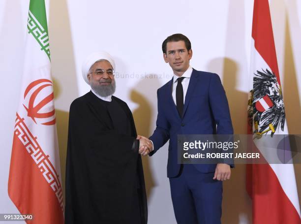 Austria's Chancellor Sebastian Kurz welcomes Iranian President Hassan Rouhani before a meeting on July 4, 2018 at the Chancellery in Vienna. /...
