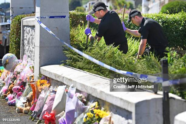 Police forensic officers search a garden at a house on Ardbeg Road on the Isle of Bute following the conformation that six year old schoolgirl Alesha...