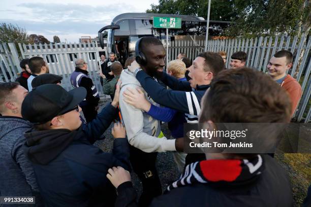 Ousseynou Cisse of MK Dons is encouraged by away fans after he got off the team bus before the AFC Wimbledon v MK Dons League One match at Cherry Red...