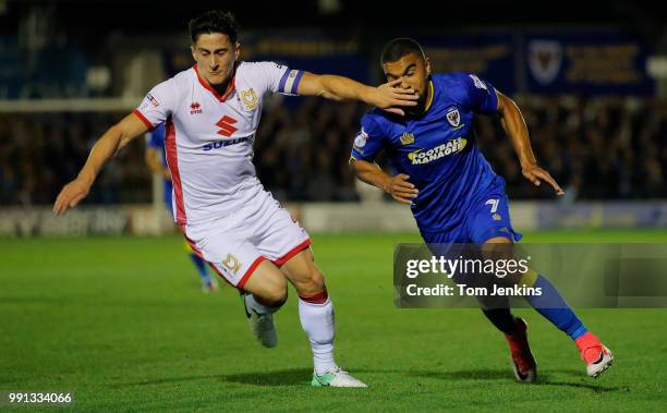 George Williams hands off Kwesi Appiah during the AFC Wimbledon v MK Dons League One match at Cherry Red Records Stadium on September 22nd 2017 in...