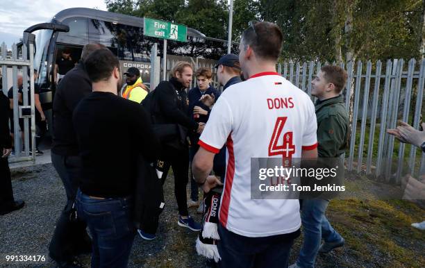 Dons manager Robbie Neilson is greeted by a small gaggle of away fans as he gets off the coach and enters the ground through the back entrance before...