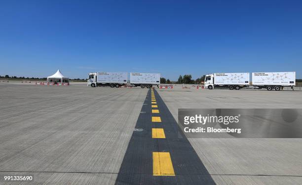 Pair of MAN SE TGX freight trucks stand on a runway during a wireless communication technology "platooning" test drive at Berlin ExpoCenter airport...