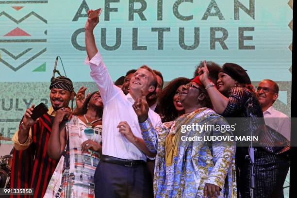 French president Emmanuel Macron takes a selfie with Nollywood artists during a live show in the AfriKa Shrine in Lagos on July 3, 2018. - French...