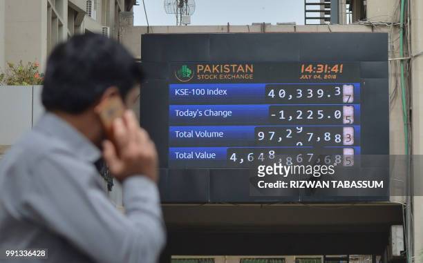 Pakistani stockbroker looks at an index board during a trading session at the Pakistan Stock Exchange in Karachi on July 4, 2018.