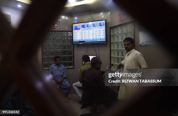 Pakistani stockbrokers work during a trading session at the Pakistan Stock Exchange in Karachi on July 4, 2018.