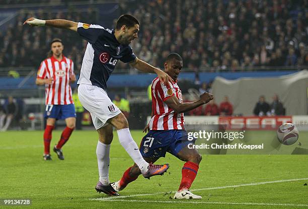 Clint Dempsey of Fulham shoots at goal while Luis Perea of Atletico Madrid can't stop him during the UEFA Europa League final match between Atletico...