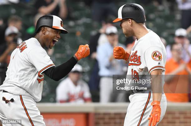 Chris Davis of the Baltimore Orioles celebrates with Tim Beckham after hitting a home run against the Seattle Mariners at Oriole Park at Camden Yards...