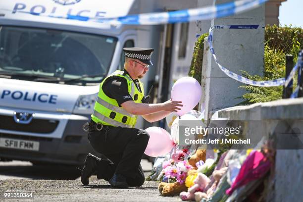 Policeman leaves balloons for a member of the public at a house on Ardbeg Road on the Isle of Bute following the conformation that six year old...