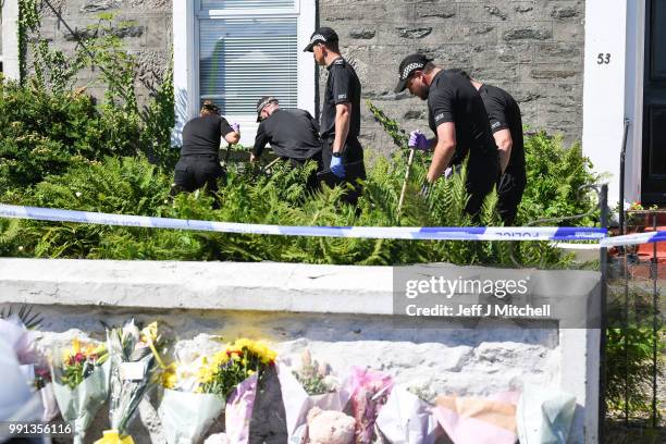 Police forensic officers search a garden at a house on Ardbeg Road on the Isle of Bute following the conformation that six year old schoolgirl Alesha...