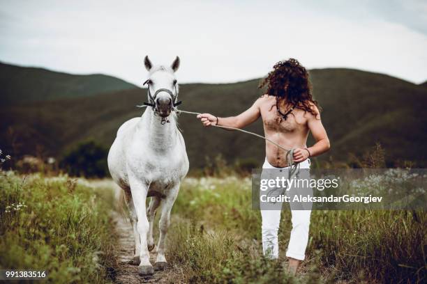 male rodeo rancher walking with his gracious stallion - gracious stock pictures, royalty-free photos & images