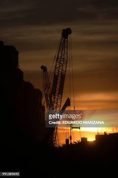 a crane in the city a summer evening - manzana stockfoto's en -beelden