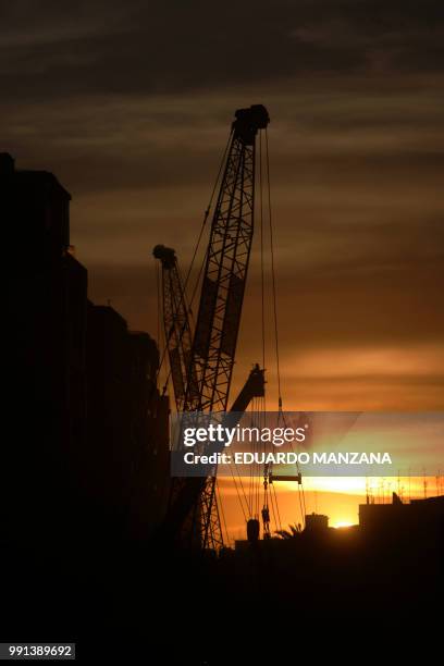a crane in the city a summer evening - manzana stock pictures, royalty-free photos & images