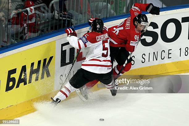 Marc Giordano of Canada is challenged by Damien Brunner of Switzerland during the IIHF World Championship group C match between Canada and...