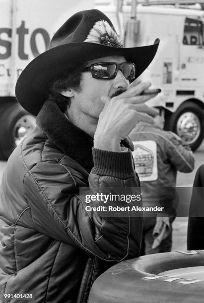 Race car driver Richard Petty smokes a cigar in the garage area at Daytona Internatonal Speedway in Daytona Beach, Florida, prior to the start of the...