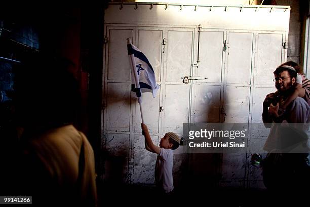 An Israeli boy waves his national flag as Israelis take part in a march marking Jerusalem Day on May 12, 2010. In Jerusalem's old city. Israel is...