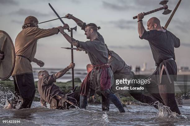 um grupo de guerreiros de viking medieval sangrento confronto um mar frio de espadachim - barbarian - fotografias e filmes do acervo