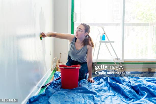 junge frau, die wände zu waschen, bevor sie zu malen. - martinedoucet stock-fotos und bilder