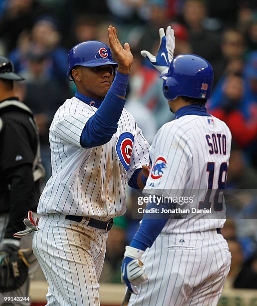 Starlin Castro of the Chicago Cubs is greeted by teammate Geovany Soto after scoring a run in the 5th inning against the Florida Marlins at Wrigley...