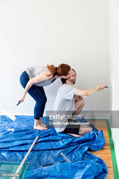 young couple painting living room in first appartement. - "martine doucet" or martinedoucet stock pictures, royalty-free photos & images