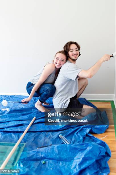 young couple painting living room in first appartement. - "martine doucet" or martinedoucet stock pictures, royalty-free photos & images
