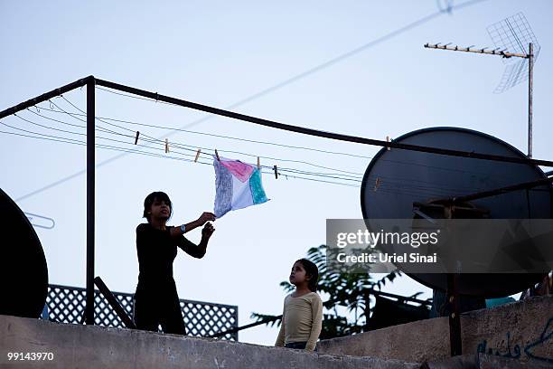 Palestinian children hung a home made Palestinian flag on there roof top as Israelis take part in a march marking Jerusalem Day on May 12, 2010. In...