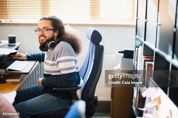 portrait smiling, confident creative businessman with headphones working in office - vanguardians stock pictures, royalty-free photos & images